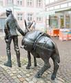 Mann zieht mit Esel zum Markt.